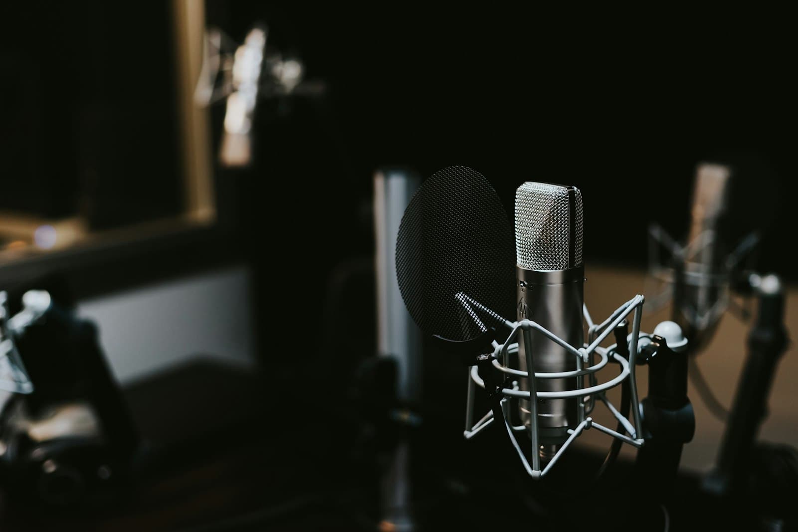 A silver microphone against blue stage lights
